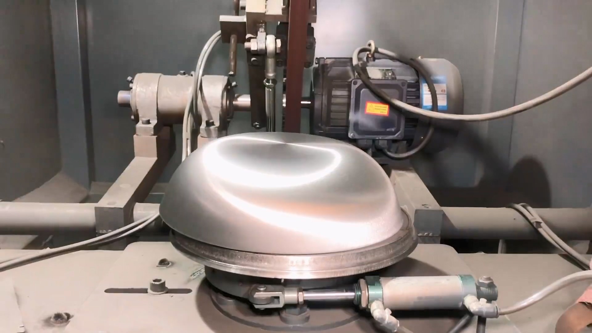 polishing the bottom of the pot using a belt sander