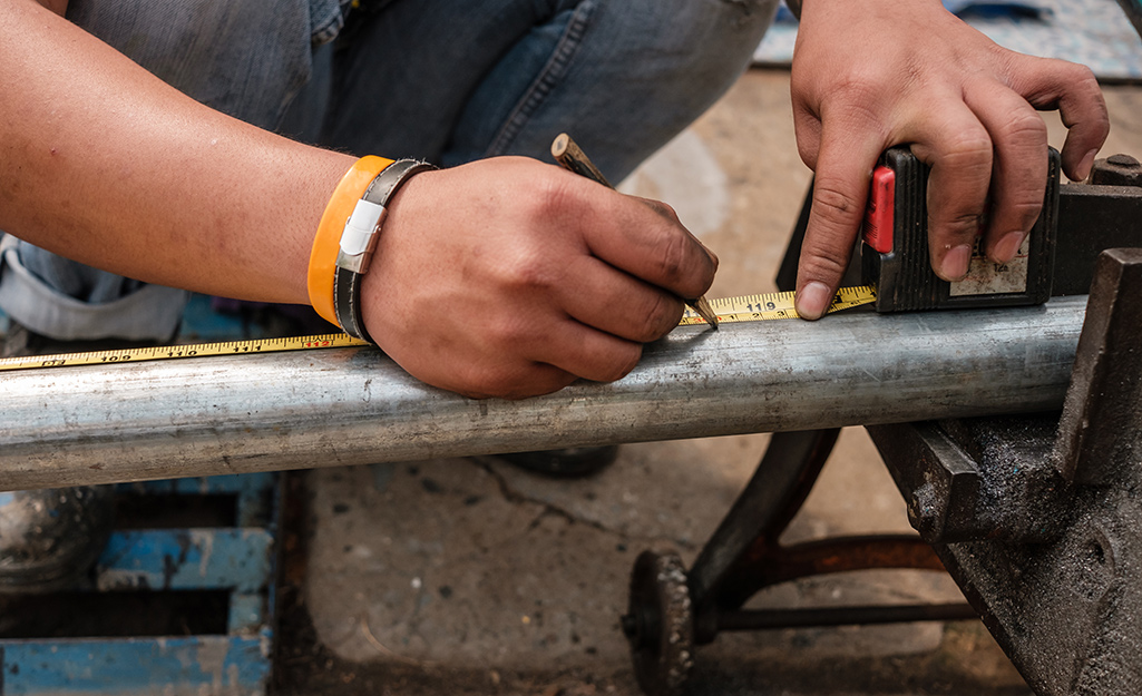 makes a mark on a length of steel pipe