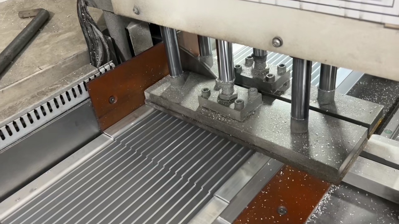 Pieza de trabajo de aluminio sujeta en una prensa acolchada de goma para evitar deformaciones durante el corte