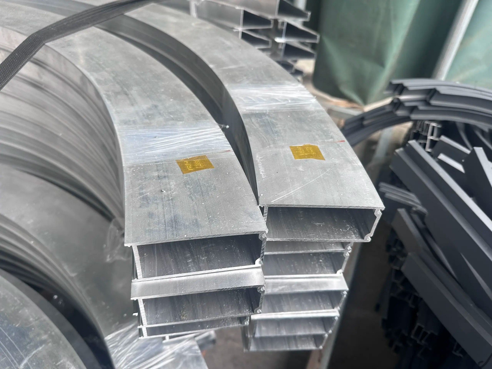 curved aluminum profiles stacked and wrapped in plastic film