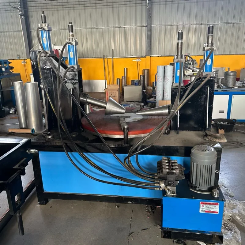 Крупный план основной конструкции конусопрокатного станка дискового типа, демонстрирующий двойные гидравлические колонны и вращающийся рабочий стол, на заднем плане — складское помещение завода.