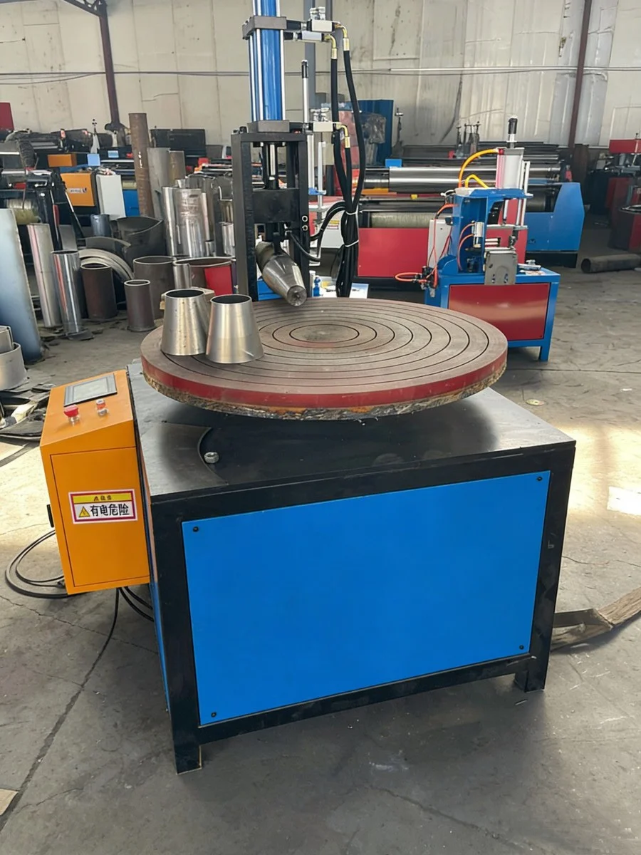 Вся машина для прокатки конусных дисков AKE DCR синего и оранжевого цвета в заводских условиях, с коническими трубами из нержавеющей стали на рабочем столе.