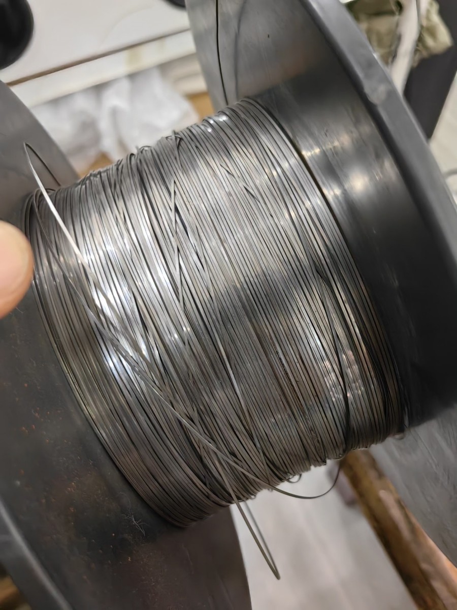 Primer plano de un alambre plano de acero inoxidable de precisión en una bobina.