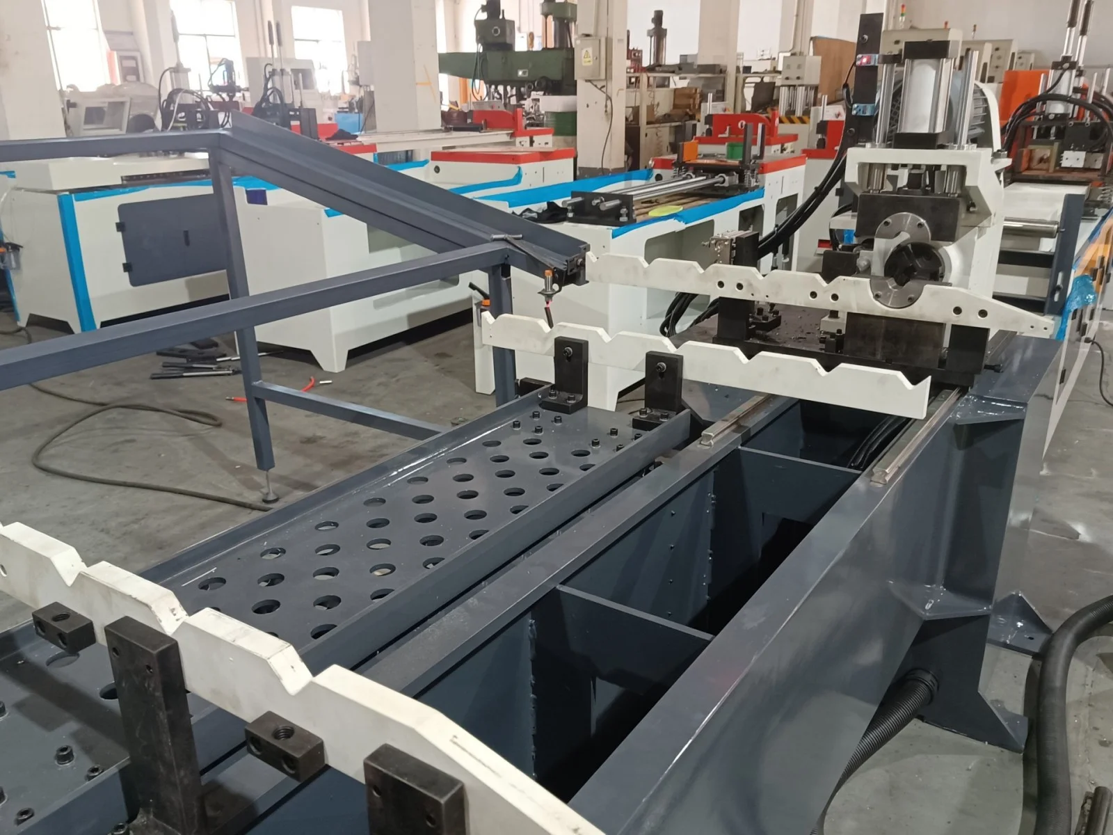 workpiece support and conveying system of double head cnc chamfering machine showing long material positioning bracket